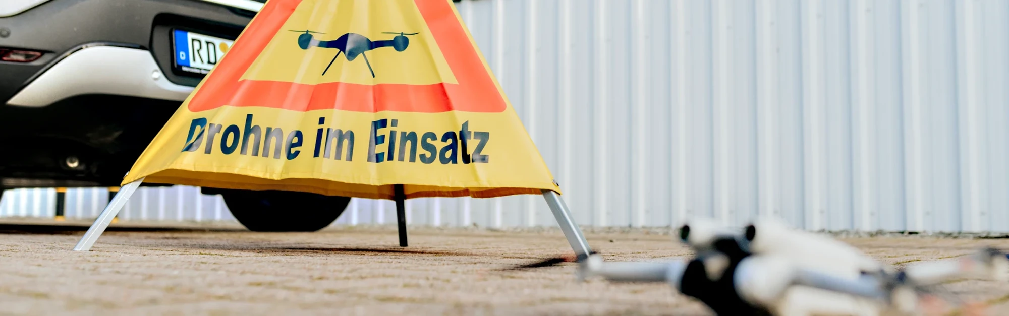 Hinweisaufsteller mit der Aufschrift "Drohne im Einsatz"