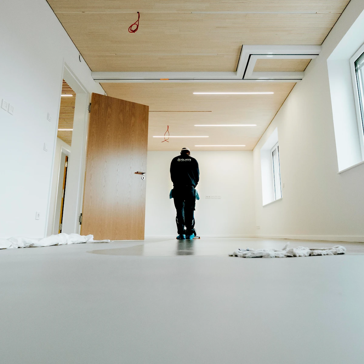 Glaus Mitarbeiter reinigt den Boden eines Raumes